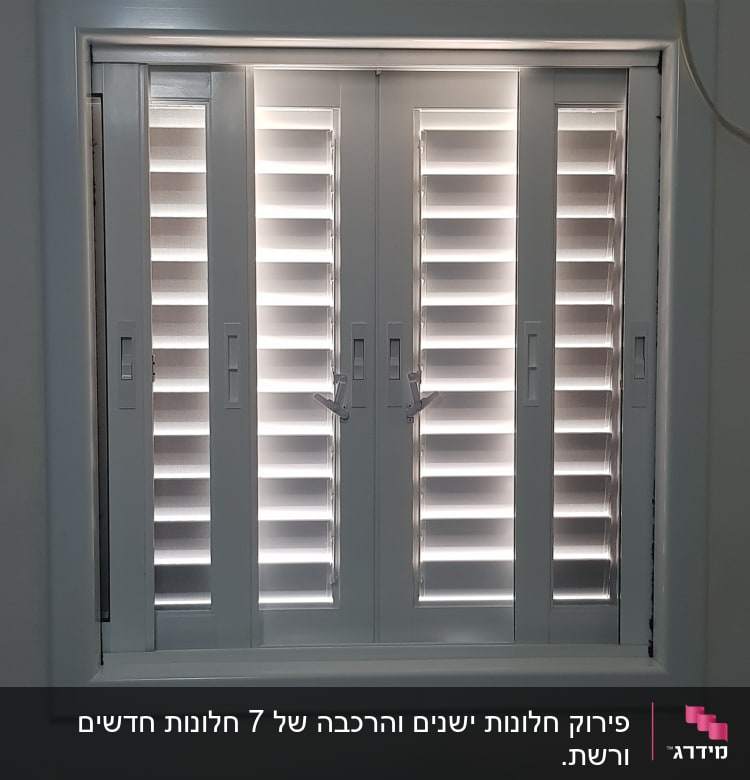 Aluminium shutters with horizontal slats in a window frame.